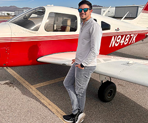 Dr. David Shockey standing in front of a private Piper aircraft.
